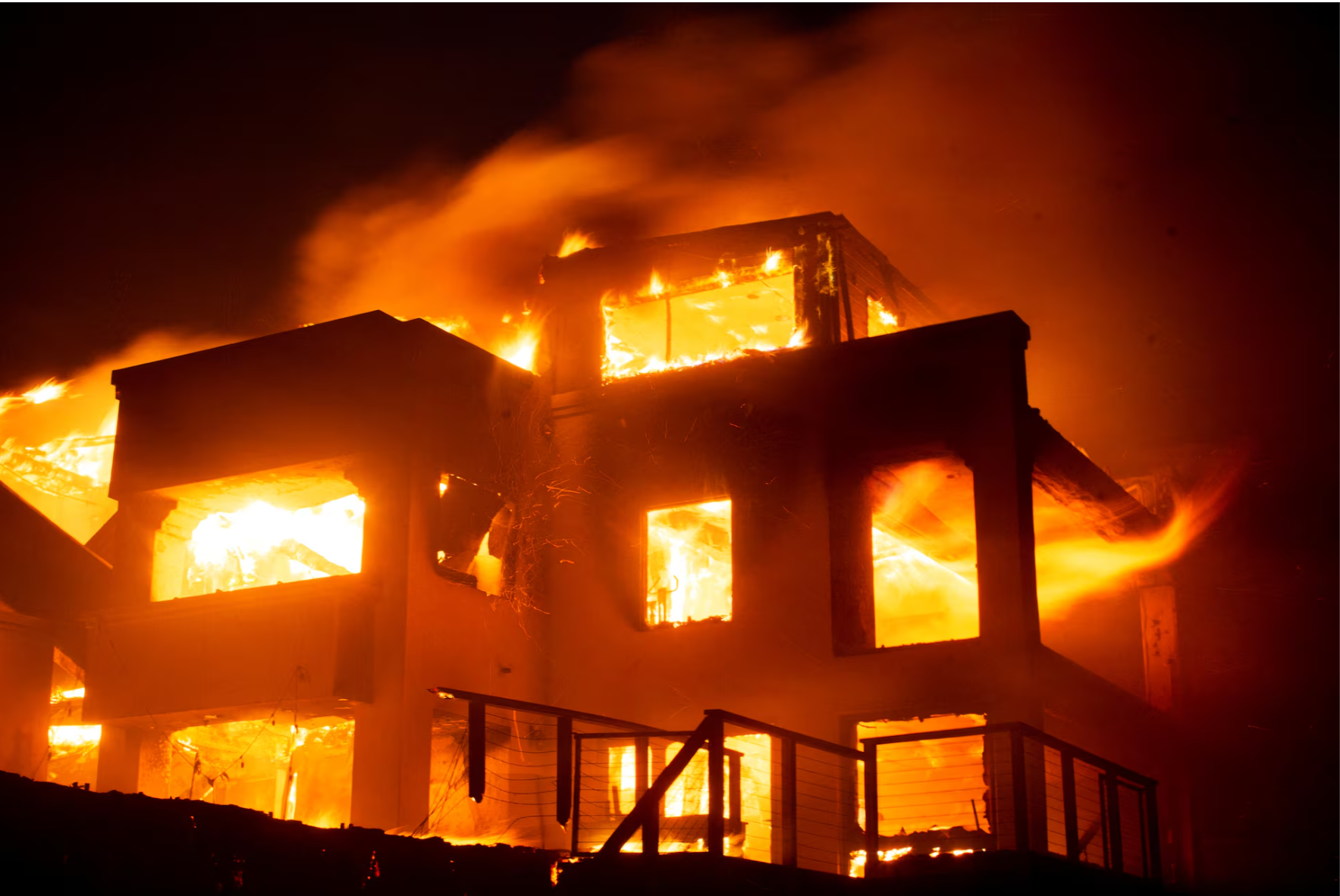 Flames rise from a structure as the Palisades fire burns during a windstorm on the west side of Los Angeles, California, U.S. January 8, 2025.