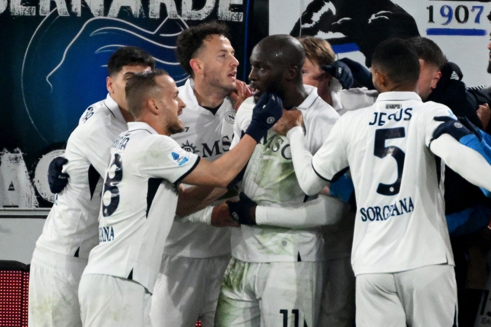 Napoli’s Belgian forward Romelu Lukaku celebrates with team mates after scoring his team third goal.— Picture from AFP